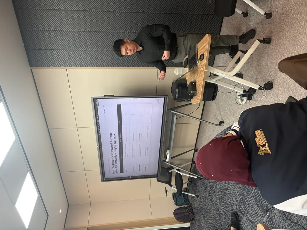 Jia Wei walking the TNB room through open-source skills on screen