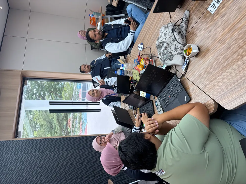 TNB participants working together at a table with laptops